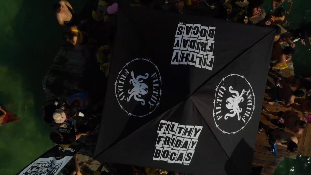 Crowd gathered under Filthy Friday Bocas umbrellas during the famous island party in Bocas del Toro, Panama.